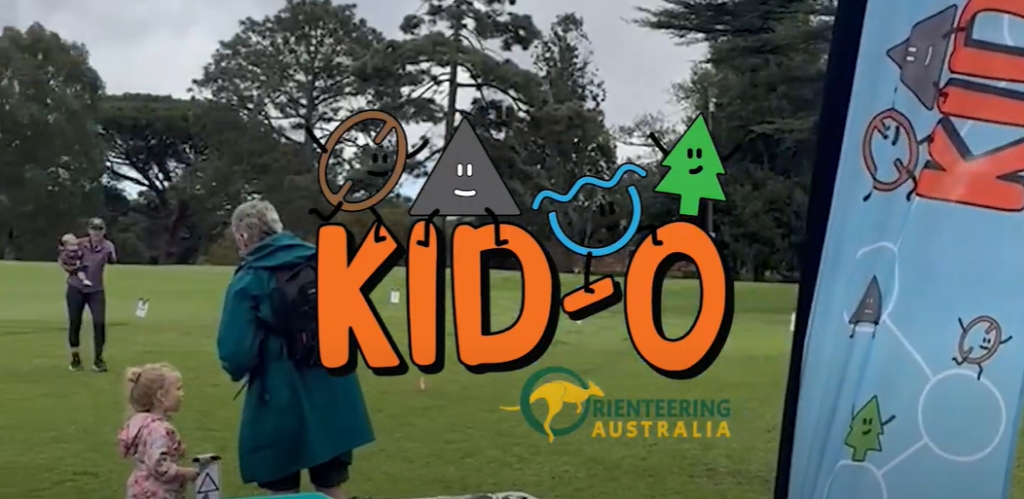 KID-O logo in front of participants doing a KID-O activity in a park