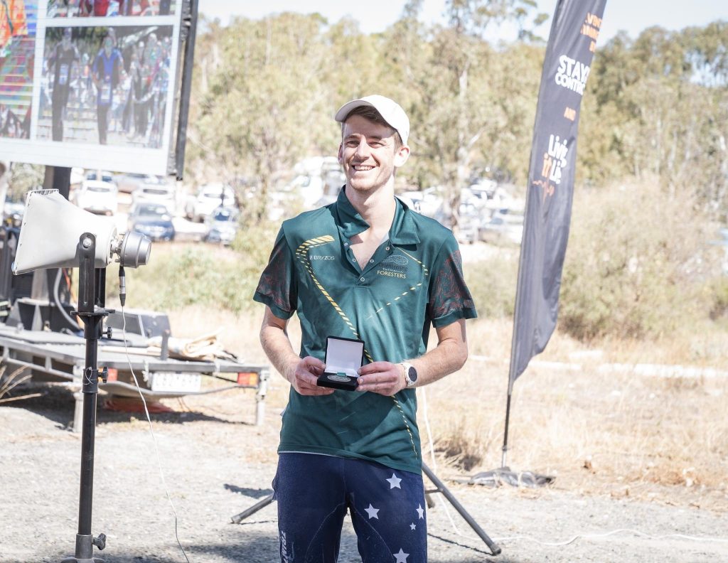 Image of Brodie receiving an award at a bush orienteering event
